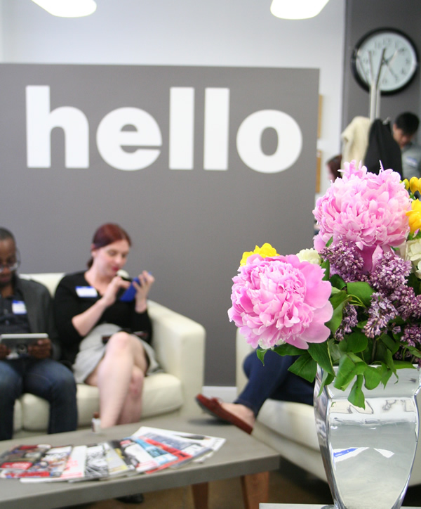A lobby with a hello sign and flowers